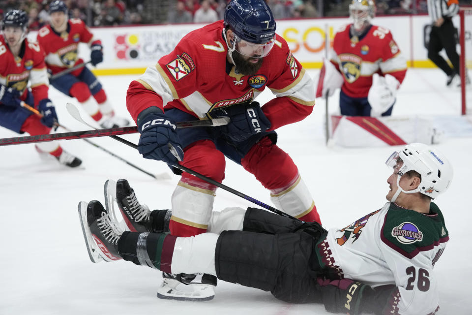 Florida Panthers defenseman Radko Gudas (7) collides with Arizona Coyotes center Laurent Dauphin (26) as they battle for the puck during the first period of an NHL hockey game, Tuesday, Jan. 3, 2023, in Sunrise, Fla. (AP Photo/Wilfredo Lee)