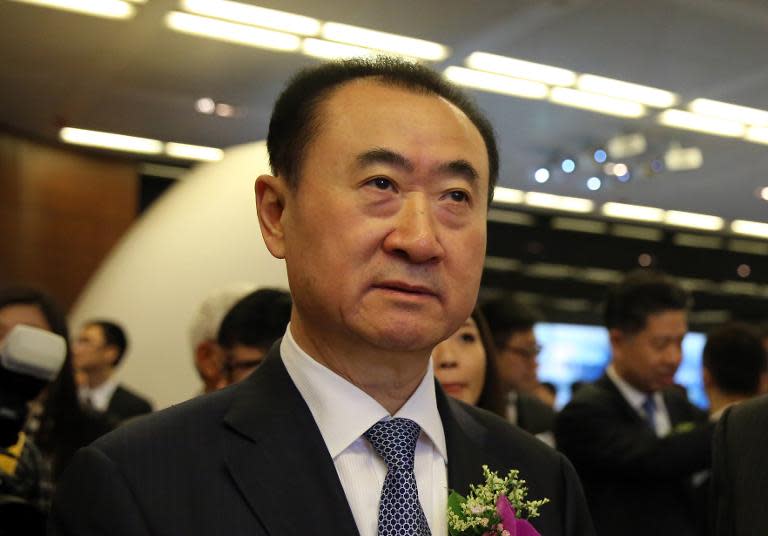 Wang Jianlin (C), CEO of Dalian Wanda Commercial Properties Co., arrives for the company's IPO at the Hong Kong stock exchange, on December 23, 2014