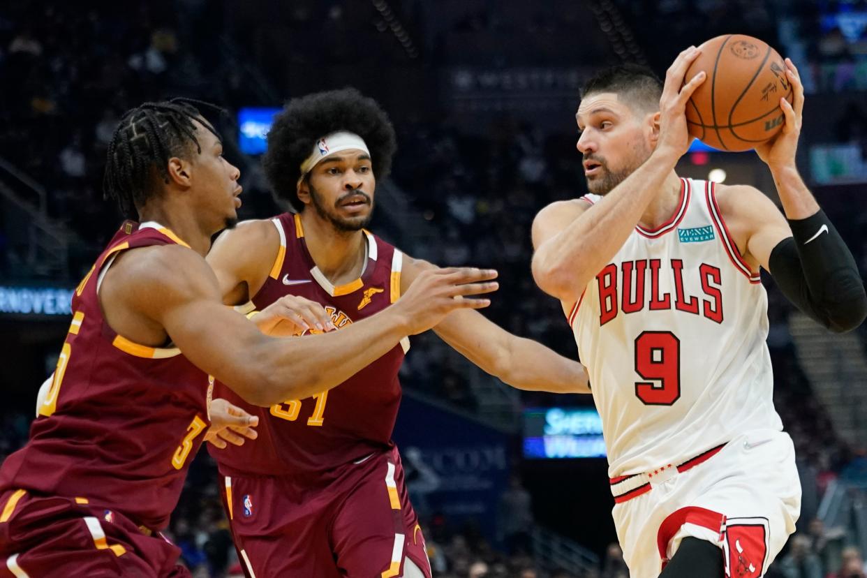 Cavaliers' Isaac Okoro (35) and Jarrett Allen (31) defend the Chicago Bulls' Zach LaVine during Wednesday night's game in Cleveland. The Cavs won 115-92 to up their record to 14-12. [Tony Dejak/Associated Press]