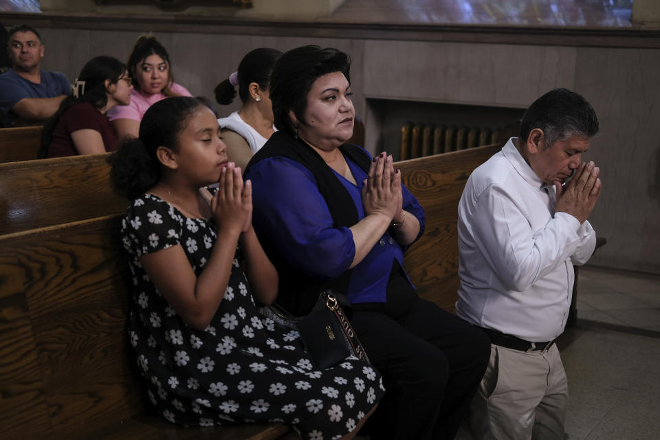 Parishioners Rosa Romero, center, and Jesus Romero, right, pray at St. Peter the Apostle Catholic Church in Reading, Pa., on Sunday, June 9, 2024. (AP Photo/Luis Andres Henao)