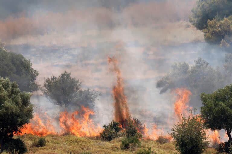 Fires burn the vegetation after rockets launched from southern Lebanon landed on the outskirts of Safed, in Israel's upper Galilee, on June 12, 2024. Lebanon's Hezbollah, a Hamas ally, and Israel have been trading near-daily fire since the Gaza war was trigged by the Palestinian militant group's October 7 attack on southern Israel. (Photo by Jalaa MAREY / AFP)