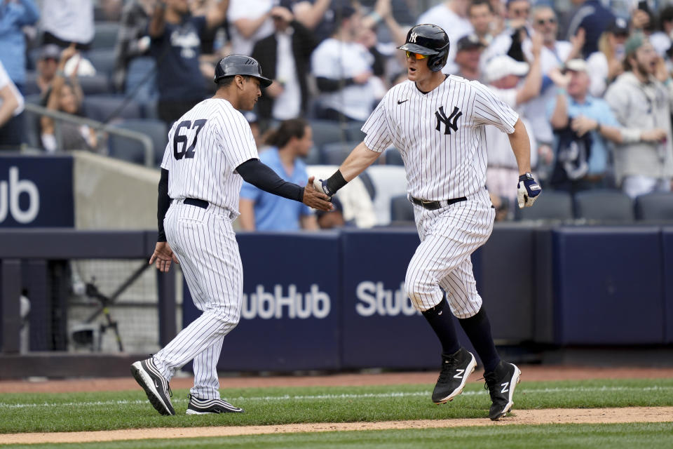 New York Yankees' DJ LeMahieu, right, celebrates with third base coach Luis Rojas (67) as he runs the bases after hitting a solo home run off Minnesota Twins starting pitcher Pablo Lopez in the sixth inning of a baseball game, Sunday, April 16, 2023, in New York. (AP Photo/John Minchillo)