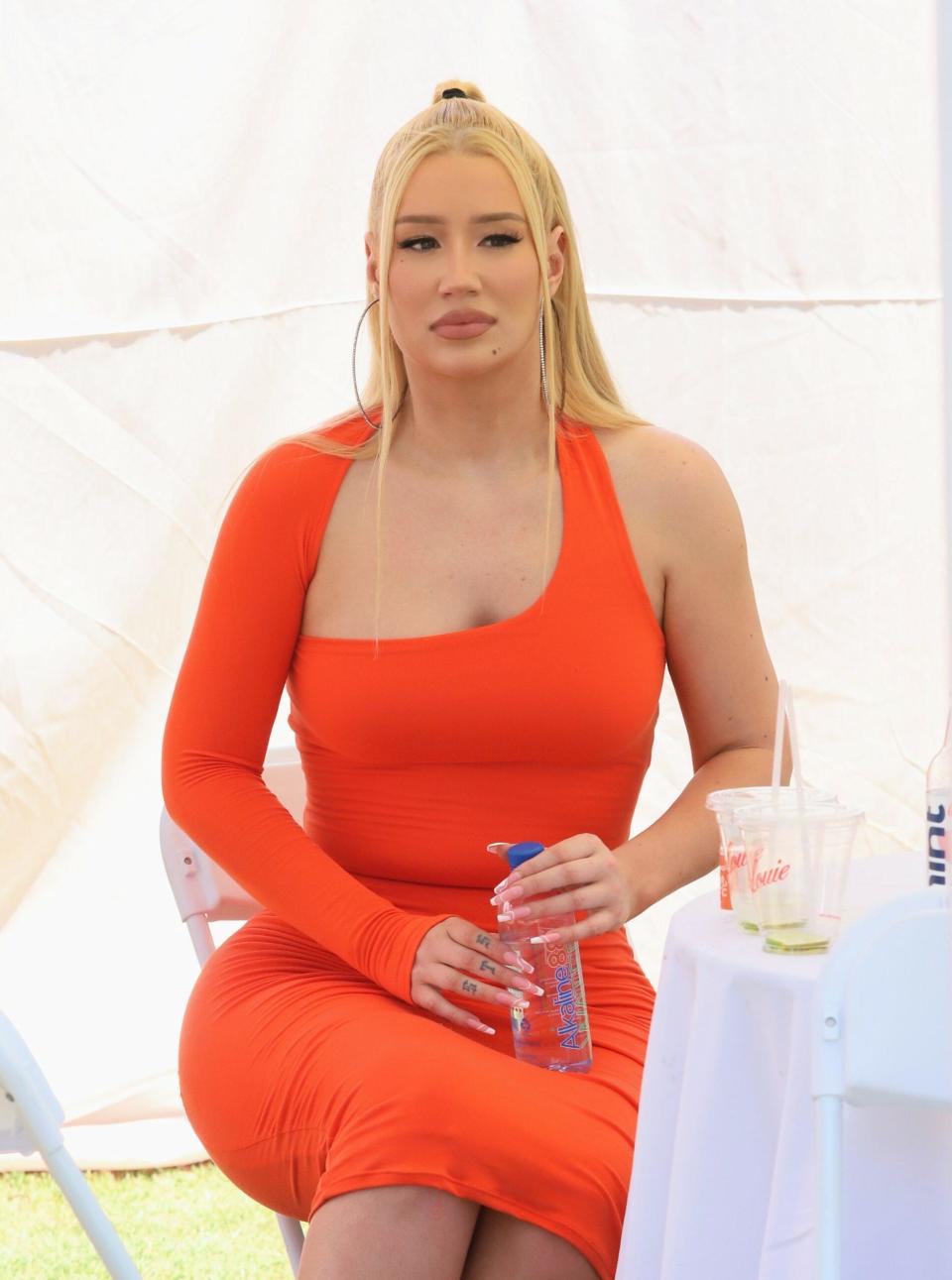 Iggy Azalea in an orange dress.