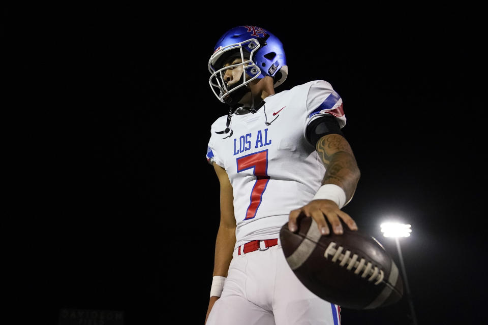 Los Alamitos High School quarterback Malachi Nelson holds a football during a high school football game against Newport Harbor High School on Friday, Sept. 30, 2022, in Newport Beach, Calif. (AP Photo/Ashley Landis)