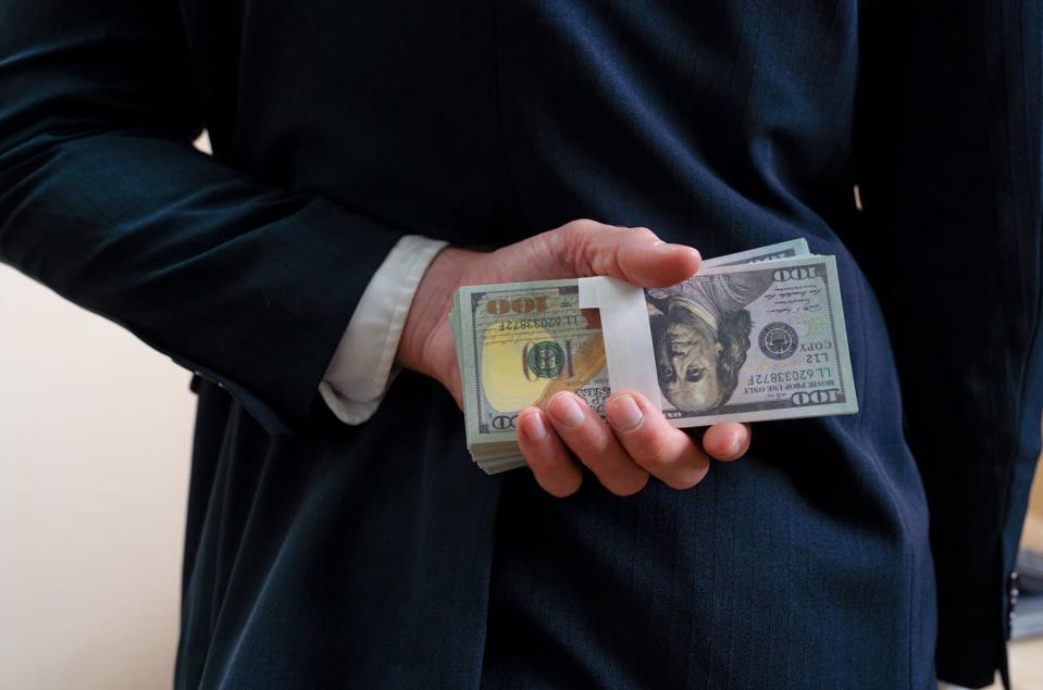 A little trust can be a dangerous thing. <a href="https://www.gettyimages.com/detail/photo/businessman-holding-money-money-us-dollar-behind-royalty-free-image/2025589329" rel="nofollow noopener" target="_blank" data-ylk="slk:Kmatta via Getty Images;elm:context_link;itc:0;sec:content-canvas" class="link ">Kmatta via Getty Images</a>