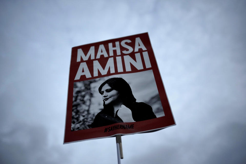 A woman holds a placard with a picture of Iranian woman Mahsa Amini during a protest against her death, in Berlin, Germany, Wednesday, Sept. 28, 2022.  / Credit: Markus Schreiber / AP