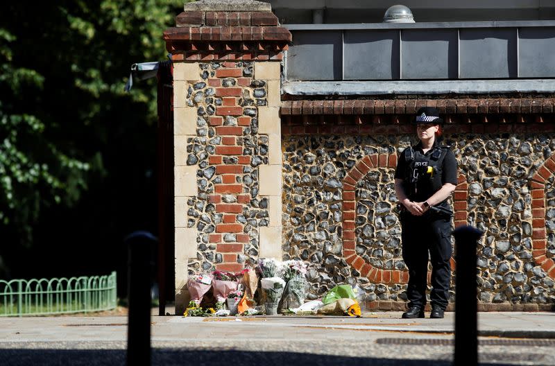 A police officer stands observing minute's silence near to the scene of reported multiple stabbings in Reading