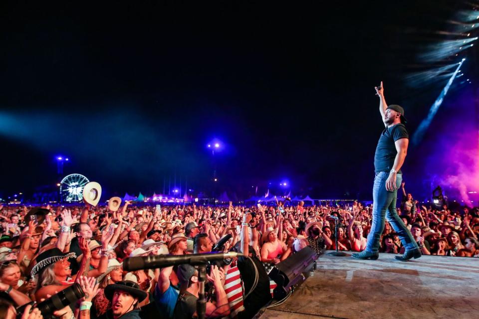 A large crowd cheers as first day headliner Luke Bryan performs on the Mane Stage.