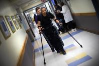 22-year-old Errol Samuels from Queens, New York, who lost the use of his legs in 2012 after a roof collapsed onto him at an off-campus house party near where he was attending college in upstate New York, walks with a ReWalk electric powered exoskeletal suit during a therapy session with Alexandra Voigt, a clinical research coordinator and therapist, at the Mount Sinai Medical Center in New York City March 26, 2014. Made by the Israeli company Argo Medical Technologies, ReWalk is a computer controlled device that powers the hips and knees to help those with lower limb disabilities and paralysis to walk upright using crutches. Allan Kozlowski, assistant professor of Rehabilitation Medicine at Icahn School of Medicine at Mount Sinai hospital, where patients like Samuels are enrolled in his clinical trials of the ReWalk and another exoskeleton, the Ekso (Ekso Bionics) says machines like these will soon offer victims of paralysis new hope for a dramatically improved quality of life and mobility. The ReWalk is currently only approved by the U.S. Food and Drug Administration (FDA) for use in rehabilitation facilities like at Mount Sinai, as they weigh whether to approve the device for home use as it already is in Europe. Picture taken March 26, 2014. REUTERS/Mike Segar