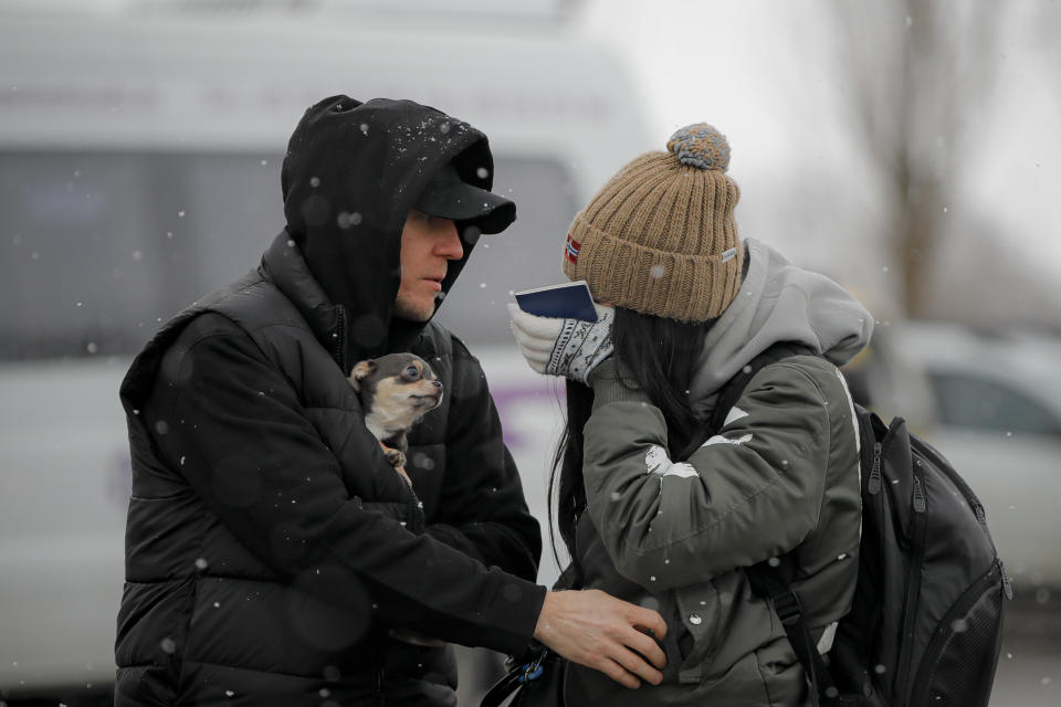 A refugee fleeing the conflict from neighboring Ukraine wipes away tears after seeing a relative at the Romanian-Ukrainian border, in Siret, Romania, Monday, March 7, 2022. (AP Photo/Andreea Alexandru)