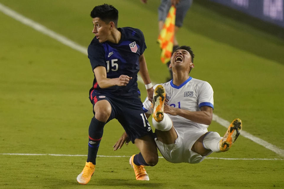 El Salvador defender Bryan Tamacas (21) goes down as he and U.S. defender Marco Farfan (15) battled for the ball during the second half of an international friendly soccer match Wednesday, Dec. 9, 2020, in Fort Lauderdale, Fla. (AP Photo/Wilfredo Lee)