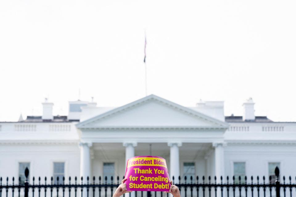 A person holds a sign thanking President Joe Biden for canceling student debt during a rally in front of the White House in Washington, in August.