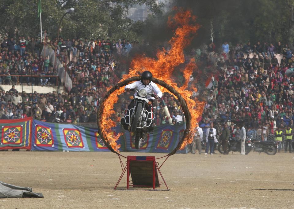 An Indian policeman performs a stunt on his motorcycle during the Republic Day parade in Jammu