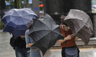 People struggle with their umbrellas against strong wind and rain in downtown Seoul, South Korea, Thursday, Sept. 3, 2020. A powerful typhoon ripped through South Korea’s southern and eastern coasts with tree-snapping winds and flooding rains Thursday, knocking out power to thousands of homes. (AP Photo/Lee Jin-man)