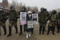 A woman holds posters as police stand blocking approaches to the square, during a protest against the jailing of opposition leader Alexei Navalny in Volgograd, Russia, Sunday, Jan. 31, 2021. Posters, left to right, read: "Today they have come after Navalny, tomorrow they will come after me, the day after tomorrow they will come after you", "Putin, you better go away yourself", "Russia will be free". Thousands of people have taken to the streets across Russia to demand the release of jailed opposition leader Alexei Navalny, keeping up the wave of nationwide protests that have rattled the Kremlin. Hundreds have been detained by police. (AP Photo/Dmitry Rogulin)