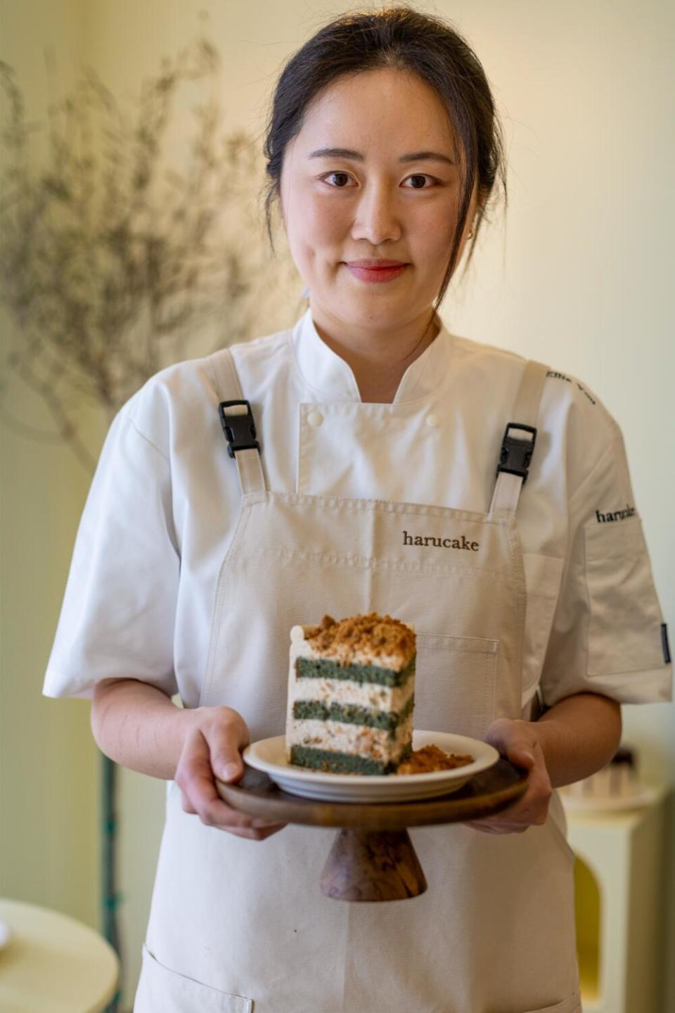 Ellie You, owner of Harucake, holds a slice of mugwort injeolmi cake.