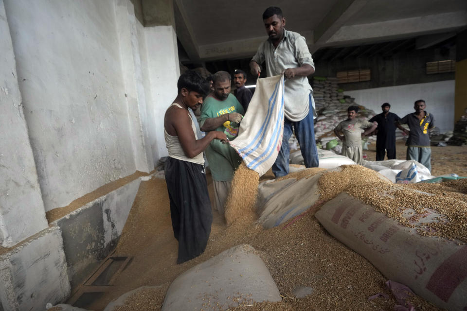Pakistani workers sort the wheat in a. warehouse in Karachi, Pakistan, on Wednesday, July 26, 2023. (AP Photo/Fareed Khan)