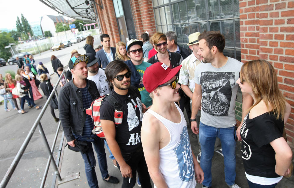 BERLIN, GERMANY - JULY 21: Attendees wait in line to enter the second annual Hipster Olympics on July 21, 2012 in Berlin, Germany. With events such as the "Horn-Rimmed Glasses Throw," "Skinny Jeans Tug-O-War," "Vinyl Record Spinning Contest" and "Cloth Tote Sack Race," the Hipster Olympics both mocks and celebrates the Hipster subculture, which some critics claim could never be accurately defined and others that it never existed in the first place. The imprecise nature of determining what makes one a member means that the symptomatic elements of adherants to the group vary in each country, but the archetype of the version in Berlin, one of the more popular locations for those following its lifestyle, along with London and Brooklyn, includes a penchant for canvas tote bags, the carbonated yerba mate drink Club Mate, analogue film cameras, asymetrical haircuts, 80s neon fashion, and, allegedly, a heavy dose of irony. To some in Berlin, members of the hipster "movement" have replaced a former unwanted identity in gentrifying neighborhoods, the Yuppie, for targets of criticism, as landlords raise rents in the areas to which they relocate, particularly the up-and-coming neighborhood of Neukoelln. (Photo by Adam Berry/Getty Images)