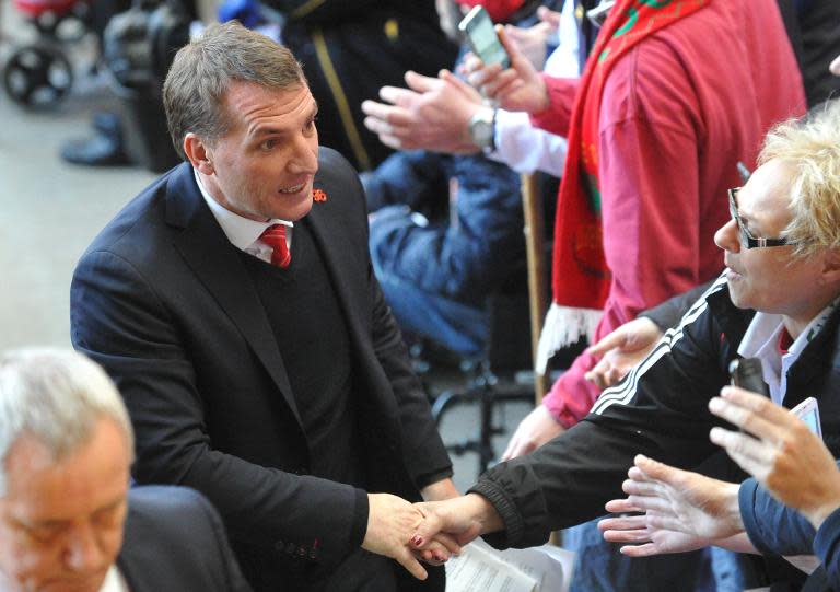 Brendan Rodgers (left) shakes hands with a supporter as he leaves at the end of a memorial service at Anfield on April 15, 2014 to mark the 25th anniversary of the Hillsborough Disaster