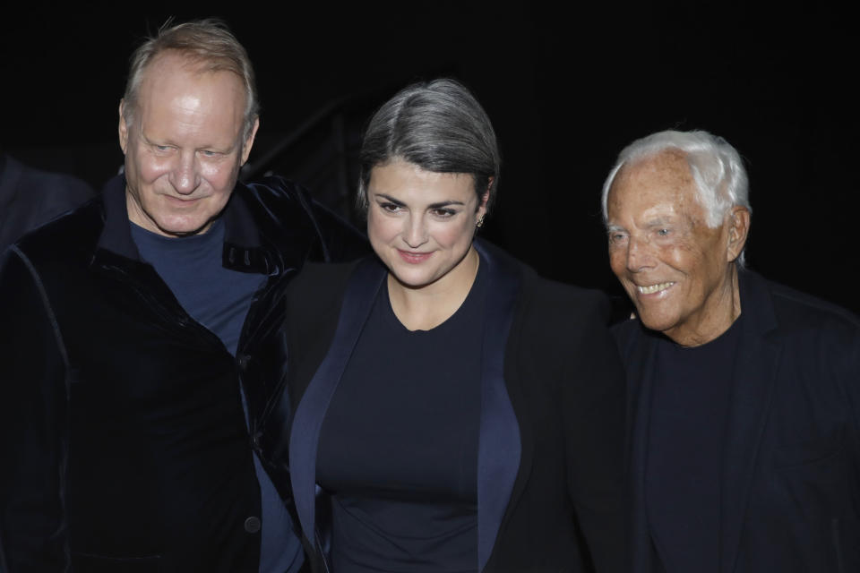 Designer Giorgio Armani, right, poses with film producer Megan Everett and actor Stellan Skarsgard after the Armani men's Fall-Winter 2020/21 collection, that was presented in Milan, Italy, Monday, Jan. 13, 2020. (AP Photo/Luca Bruno)