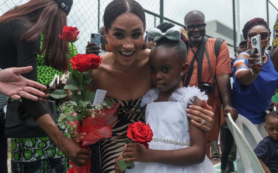 The Duchess was presented with a bouquet of red roses by Royalty Ojeh, and handed one back to the little girl