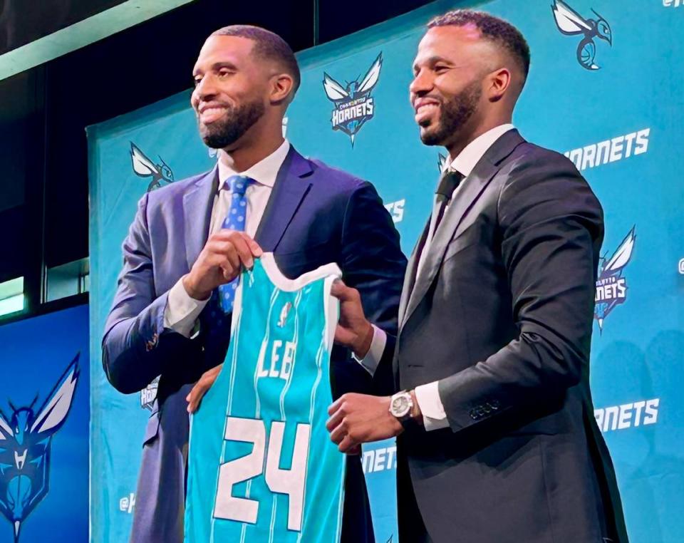 New Charlotte Hornets head coach Charles Lee (left) holds up a commemorative team jersey alongside the man who hired him, Jeff Peterson. Lee had his opening news conference on June 25, 2024, after finishing out an NBA championship season as an assistant coach with the Boston Celtics.