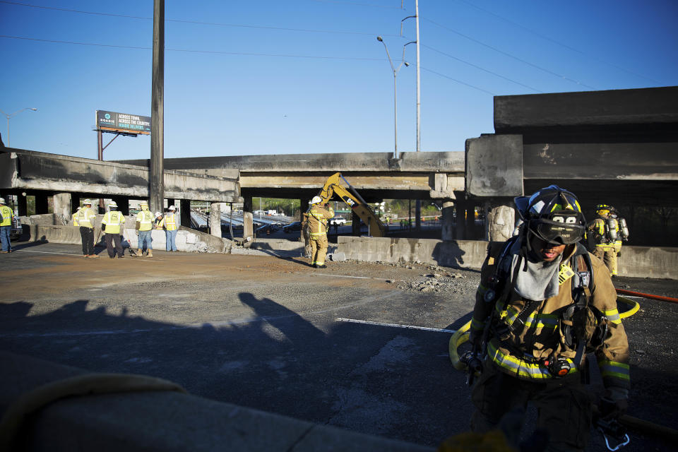 A firefighter works the scene where a section of an overpass collapsed from a large fire on Interstate 85 in Atlanta, Friday, March 31, 2017. Many commuters in some of Atlanta's densely populated northern suburbs will have to find alternate routes or ride public transit for the foreseeable future after a massive fire caused a bridge on Interstate 85 to collapse Thursday, completely shutting down the heavily traveled highway. (AP Photo/David Goldman)