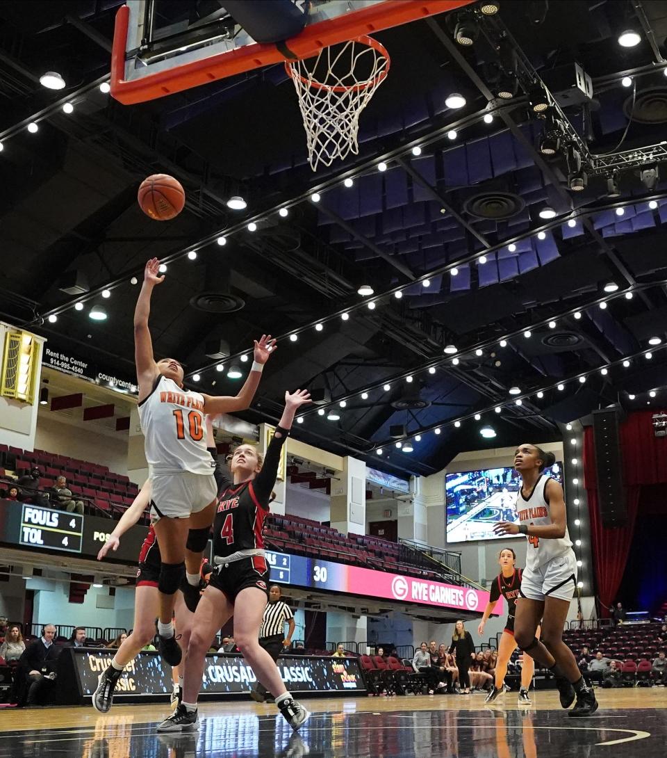 White Plains' Ineivi Plata (10) drives to the basket past Rye's Molley Kennedy (4) during the Slam Dunk Showcase at the Westchester County Center in White Plains on Friday, Jan 5, 2024. White Plains won 57-50.