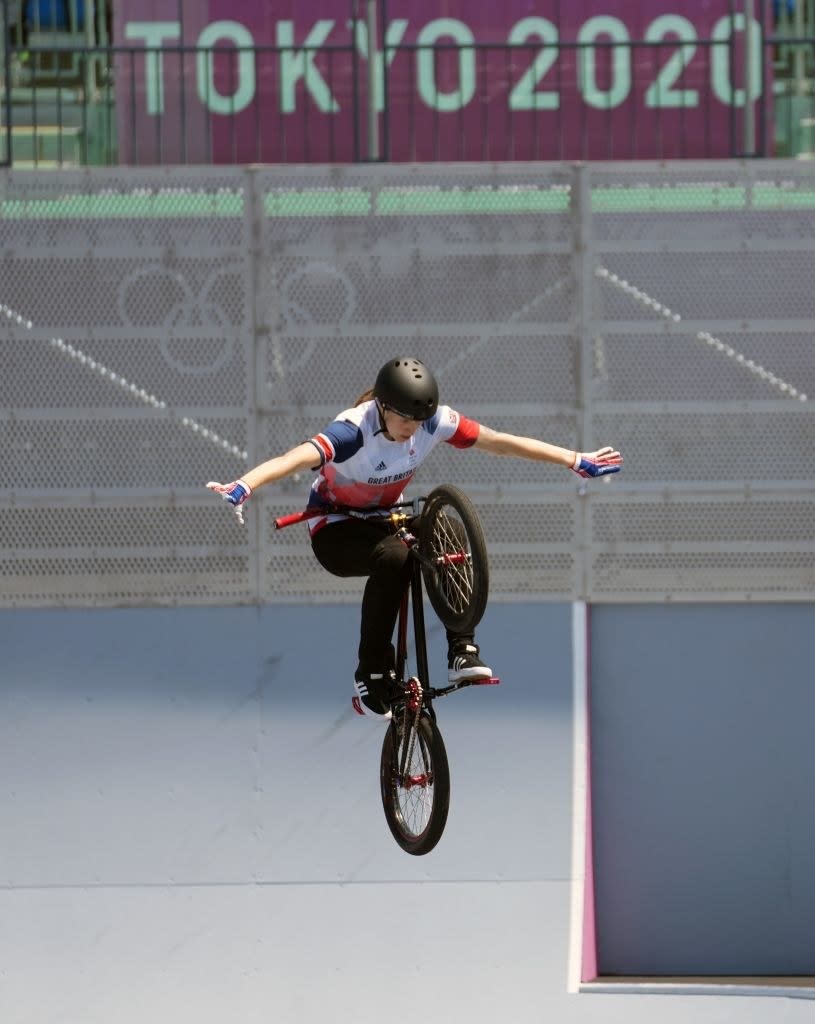 An athlete is mid-air on their bike without touching the handles