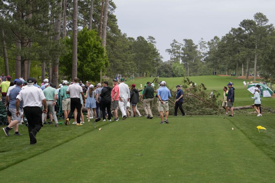 Patrons move away from trees that blew over on the 17th hole during the second round of the Masters golf tournament at Augusta National Golf Club on Friday, April 7, 2023, in Augusta, Ga. Ga. A day later there is no visible sign that trees fell on the course. (AP Photo/Mark Baker, File)