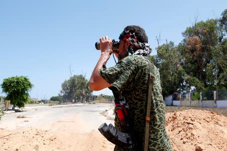 A fighter of Libyan forces allied with the U.N.-backed government looks through a pair of binoculars during a battle with Islamic State fighters in Sirte, Libya August 15, 2016. REUTERS/Ismail Zitouny