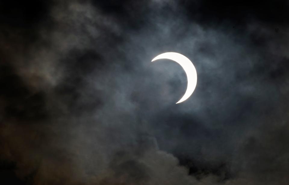 A partial annular eclipse peeks through the clouds during a watch party held by the Delta College Physics-Math-Computer Sciences Club and the Stockton Astronomical Society on the campus of San Joaquin Delta College in Stockton on Oct. 14, 2023. It began at about 8 a.m. and lasted until about 10:40 a.m. with its peak at about 9:30 a.m. About 50 people attended the event. A solar eclipse is when the moon comes between the Earth and Sun. Stockton was just outside of the eclipse's path and experiences only a partial eclipse covering most but all of the Sun. The Oct. 14 eclipse was an annular eclipse. That's when the moon is at its farthest from the Earth and it doesn't entirely block out the Sun but leaves a ring often called the "ring of fire." A total eclipse will occur on April, 8 2024.