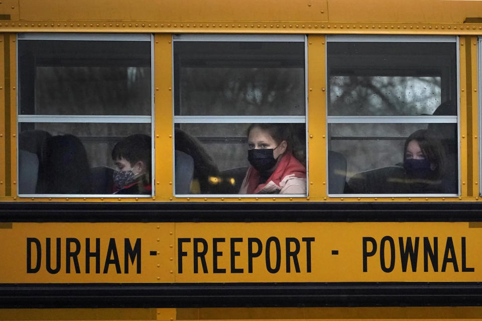 FILE - Students from Regional School Unit 5 wear COVID face coverings as they head home on a school bus, Jan. 5, 2022, in Freeport, Maine. Officials across the U.S. are again weighing how and whether to impose mask mandates as COVID-19 infections soar and the American public grows weary of pandemic-related restrictions. Much of the debate centers around the nation’s schools, some of which closed due to infection-related staffing issues. (AP Photo/Robert F. Bukaty, File)
