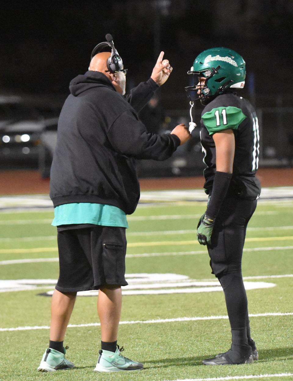 Victor Valley defensive coordinator Thomas Riley talks to Messiah Daily during the second quarter of the 100th edition of the Axe Game at Ray Moore Stadium on Thursday, Oct. 5, 2023. Barstow beat Victor Valley 49-14 to snap a three-game losing streak in the annual rivalry game.