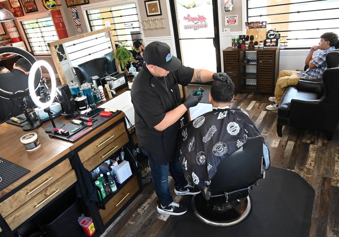 Yuniel Villasenor, owner of Money Line Barbershop, center, has won the poll for best barbershop in the area. Photographed Friday, Aug. 26, 2022 in Fresno.