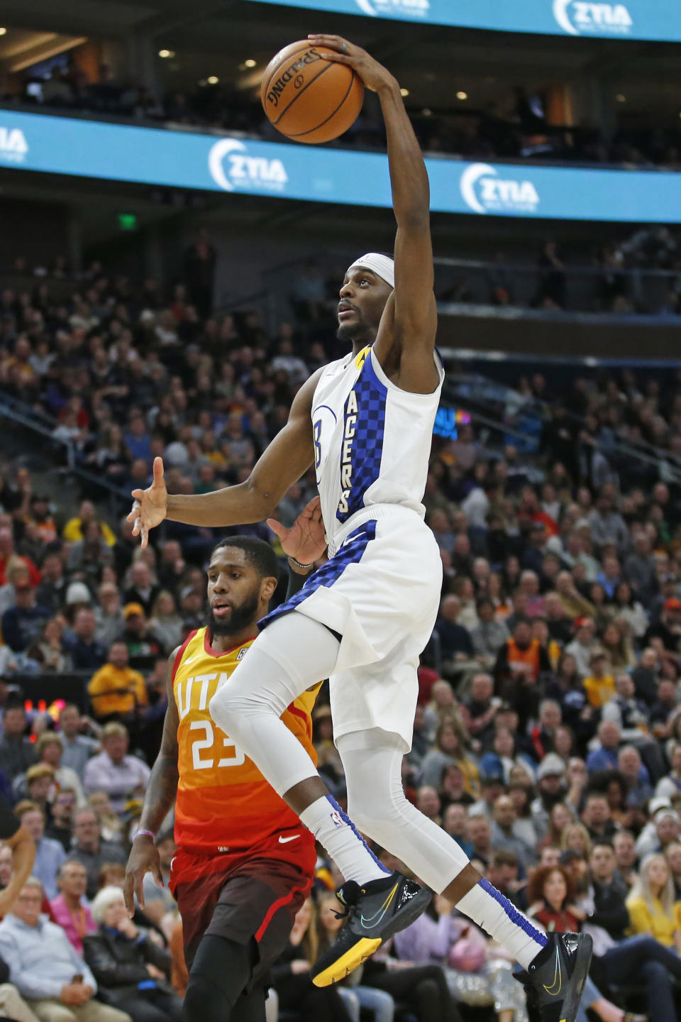 Indiana Pacers forward Justin Holiday, left, goes to the basket as Utah Jazz forward Royce O'Neale (23) defends in the first half of an NBA basketball game Monday, Jan. 20, 2020, in Salt Lake City. (AP Photo/Rick Bowmer)