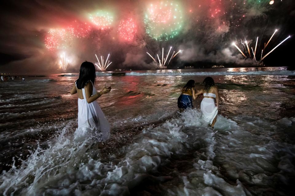 People bring in the New Year as they watch fireworks explode over Copacabana Beach in Rio de Janeiro, Brazil, early Sunday, Jan. 1, 2023. 