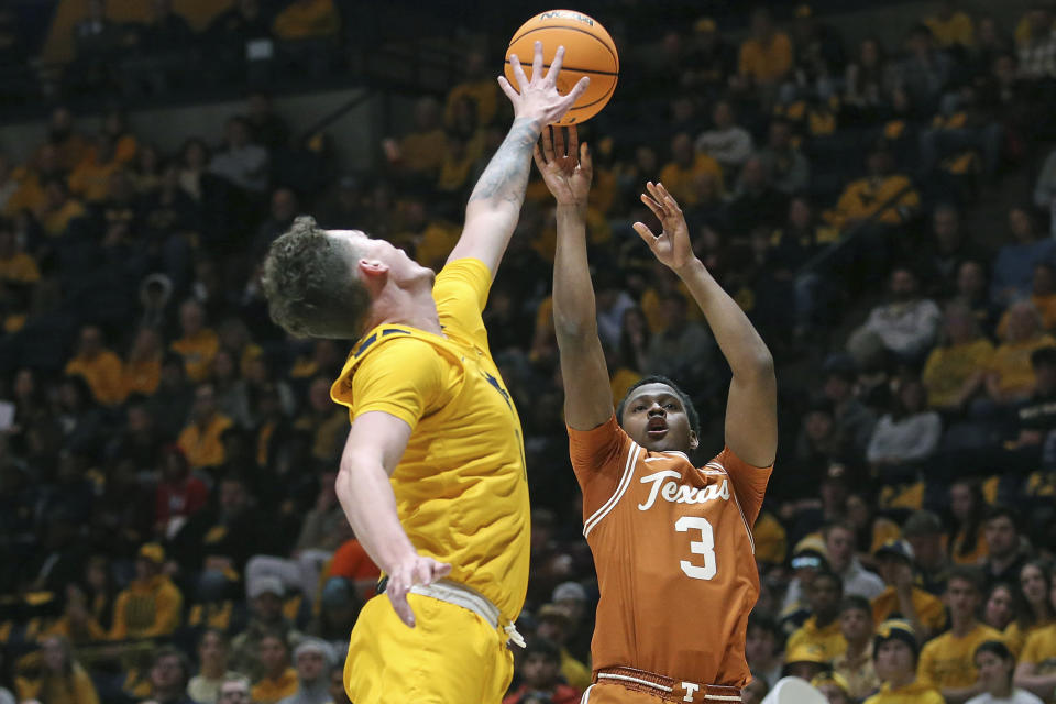 Texas guard Max Abmas (3) shoots while defended by West Virginia forward Quinn Slazinski, left, during the first half of an NCAA college basketball game on Saturday, Jan. 13, 2024, in Morgantown, W.Va. (AP Photo/Kathleen Batten)