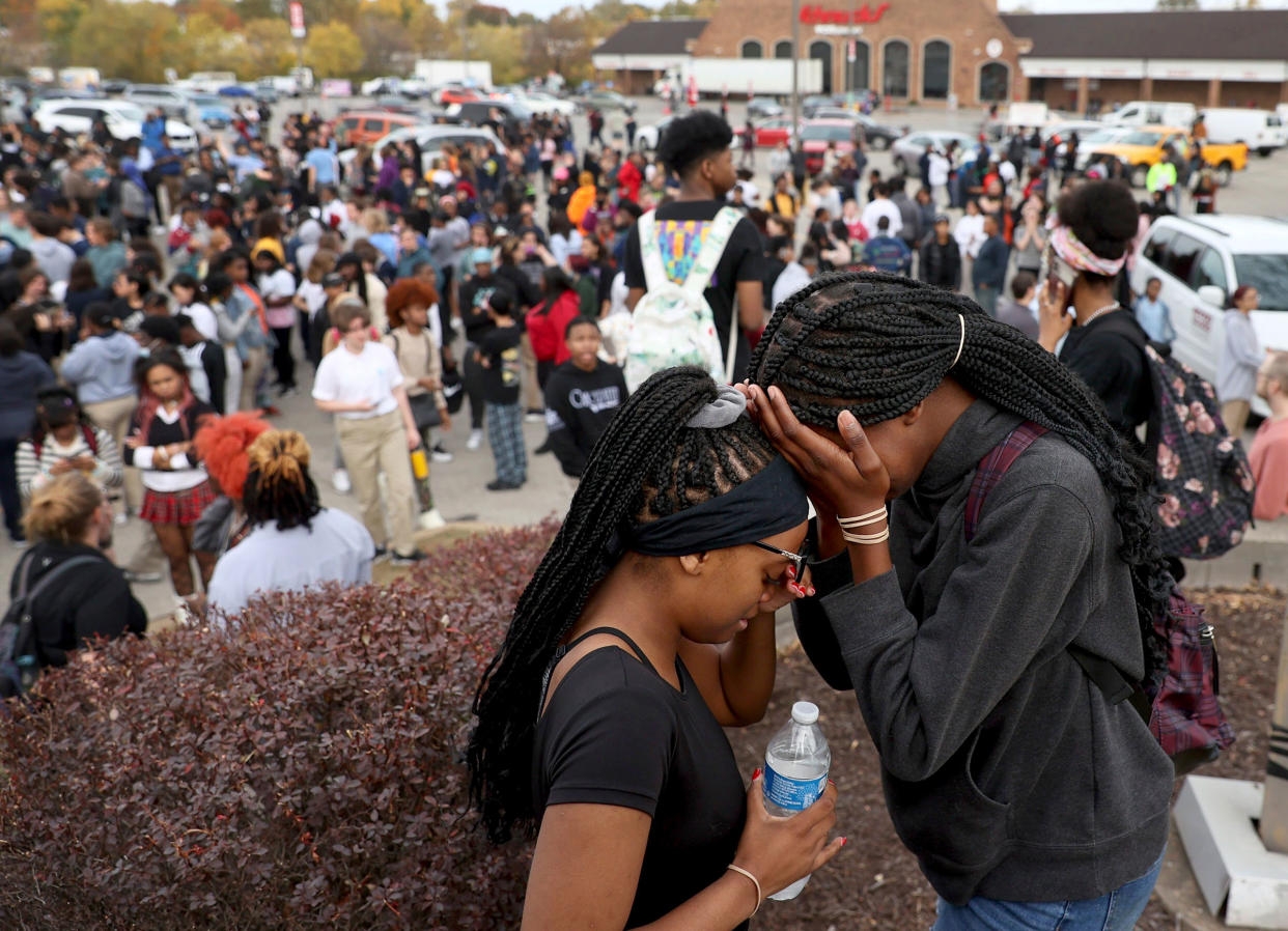 Students stand in a parking lot near the Central Visual & Performing Arts High School after a reported shooting at the school in St. Louis, on Monday, Oct. 24, 2022.