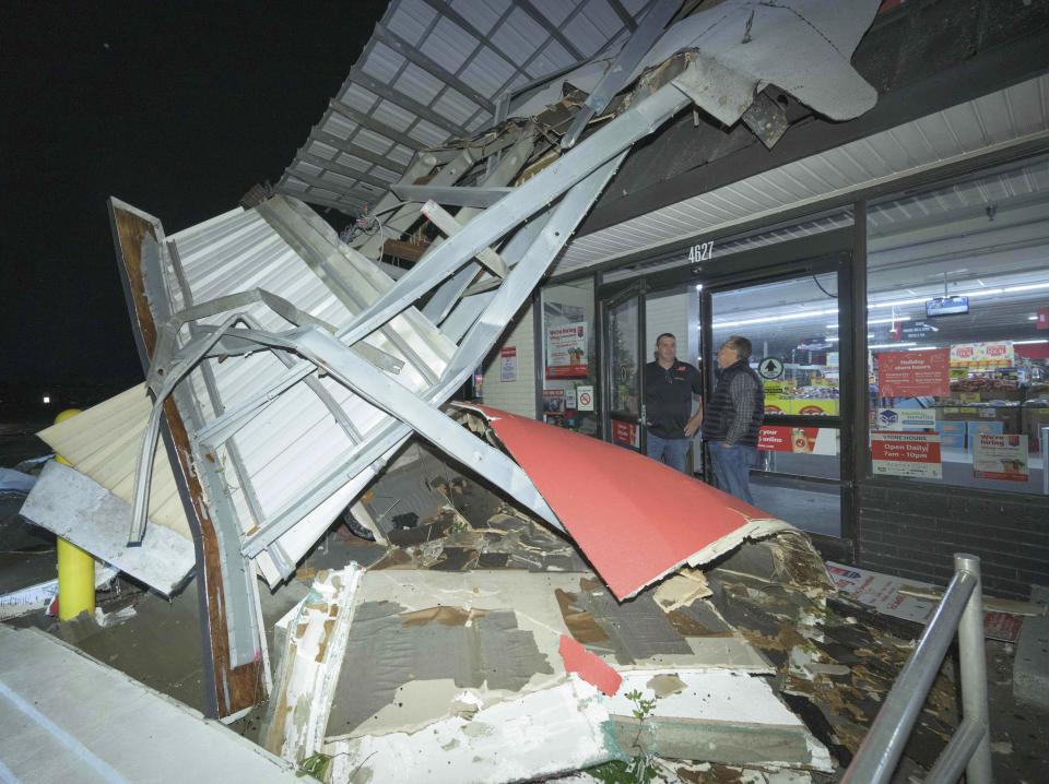 A Winn-Dixie employee talks to a customer telling them the store is closed after the facade had fallen down due to a tornado in Gretna, La., in Jefferson Parish neighboring New Orleans, Wednesday, Dec. 14, 2022. No one was injured at the store. (AP Photo/Matthew Hinton)