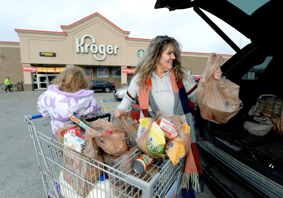 Melissa Jones of Pana puts groceries in her car after shopping at Kroger with her granddaughter Brynlynn Kay, 4, in Taylorville Wednesday Dec. 21, 2022.