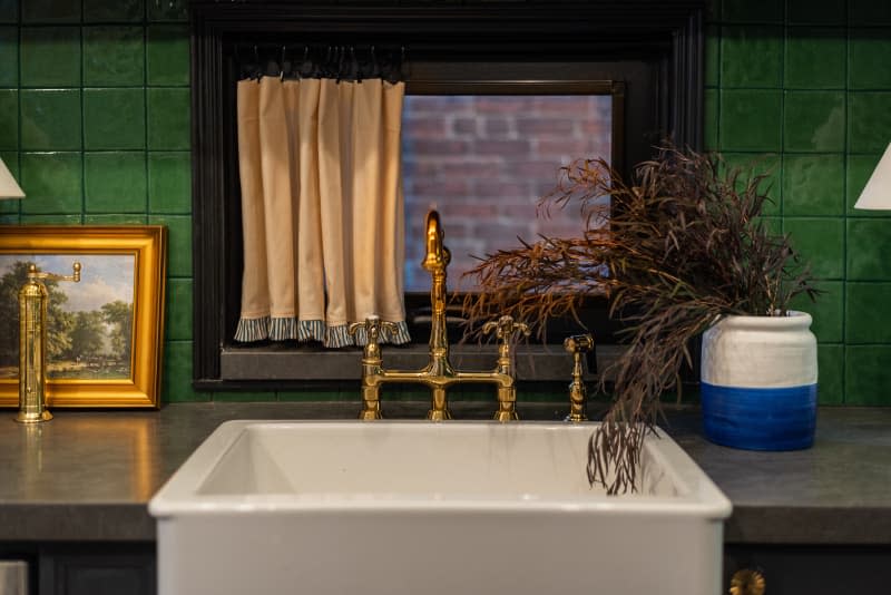 Brass hardware sink with a green backsplash