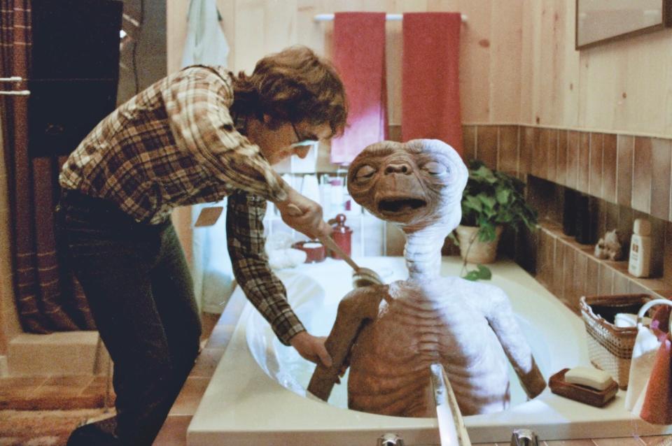 "E.T. the Extra-Terrestrial" director Steven Spielberg gives his title alien a good scrub down while filming a bath scene that was deleted from the 1982 theatrical release but restored in a 2002 special edition.