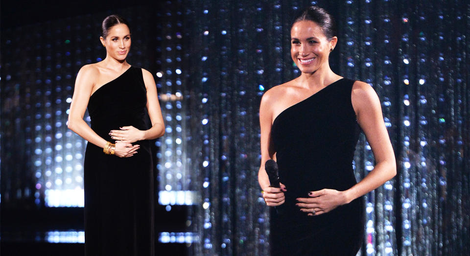 Meghan Markle hugs her bump at The Fashion Awards. [Photo: Getty]