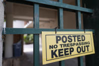 A warning sign is posted on a gate in a business park at 1512 Broward Blvd., in Fort Lauderdale, Fla., on Thursday, March 28, 2024, where Campaign Nucleus's small, unmarked office is located. Political consultant Brad Parscale's company is boosting fundraising and voter engagement for the Trump campaign and other right-wing causes. The company says it uses artificial intelligence to automate how political operatives identify and motivate their supporters, and to predict when and where they’re most likely to vote and make campaign donations. (AP Photo/Lynne Sladky)