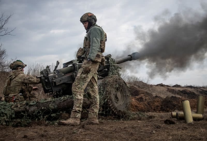 FILE PHOTO: Ukrainian service members fire a howitzer M119 at a front line near Bakhmut