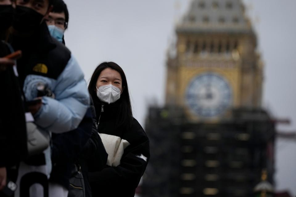 People queue to get a coronavirus booster jab at St Thomas' Hospital, backdropped by the scaffolded Elizabeth Tower, known as Big Ben, and the Houses of Parliament, in London, Monday, Dec. 13, 2021. Long lines formed at vaccination centers in Britain as people heeded the government's call for all adults to get booster shots to protect against the omicron variant of the coronavirus, which the prime minister said Monday has caused at least one death. (AP Photo/Matt Dunham)