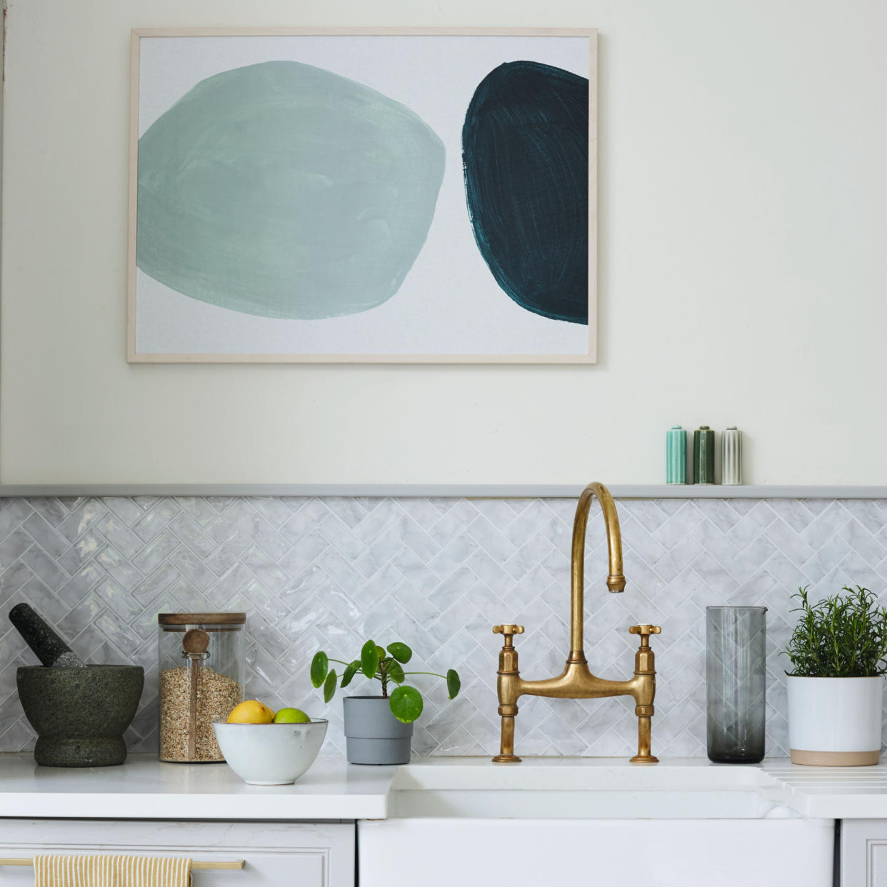  Butlers sink set into pale grey kitchen cupboards, pale grey splash back and copper taps. 