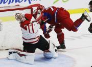 Russia's Andrei Mironov (22) runs into Canada's goalie Zachary Fucale (L) during the first period period of their IIHF World Junior Championship ice hockey game in Malmo, January 5, 2014. REUTERS/Alexander Demianchuk (SWEDEN - Tags: SPORT ICE HOCKEY)