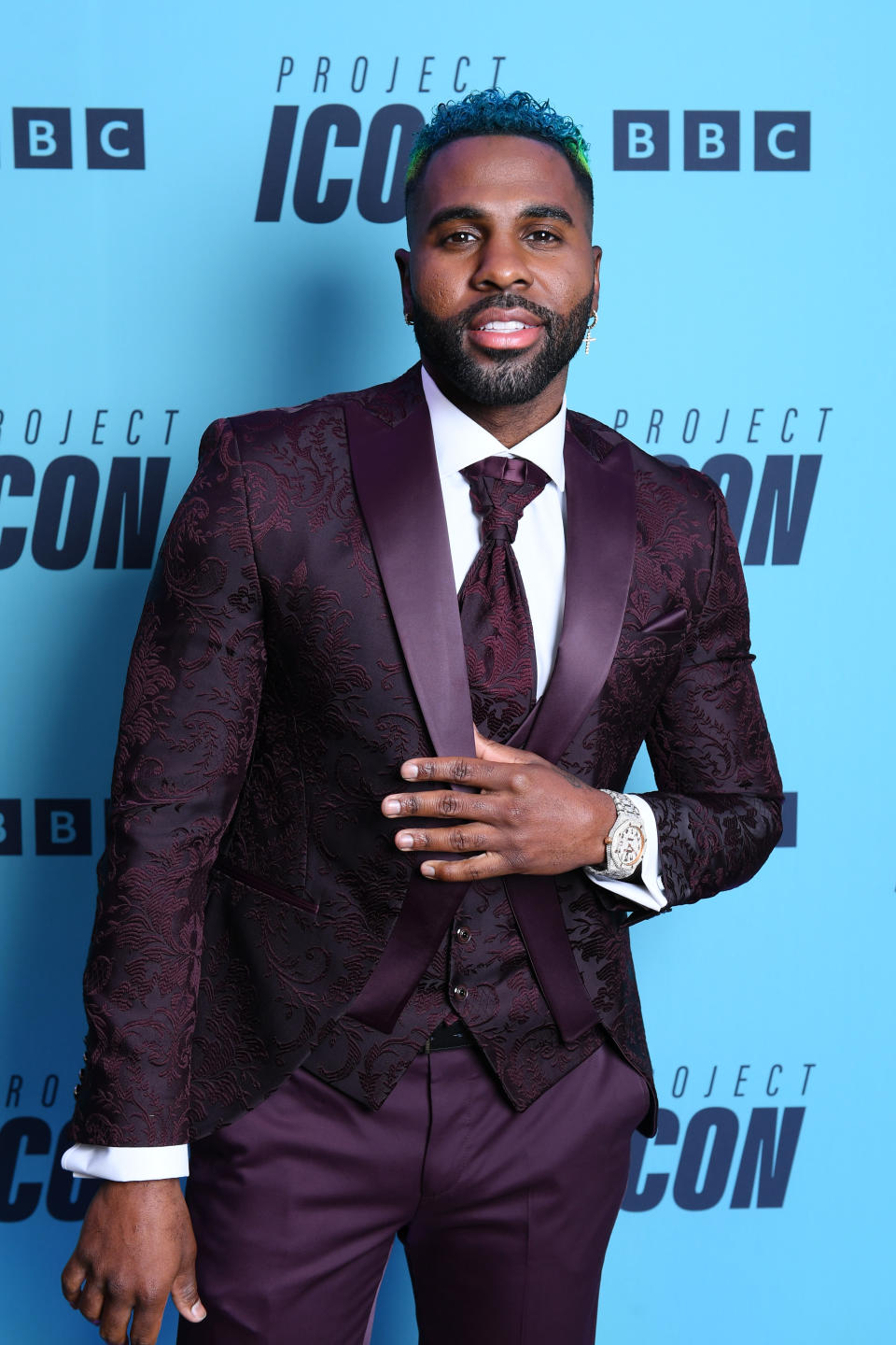 Close-up of Jason in a suit, vest, and tie at a media event